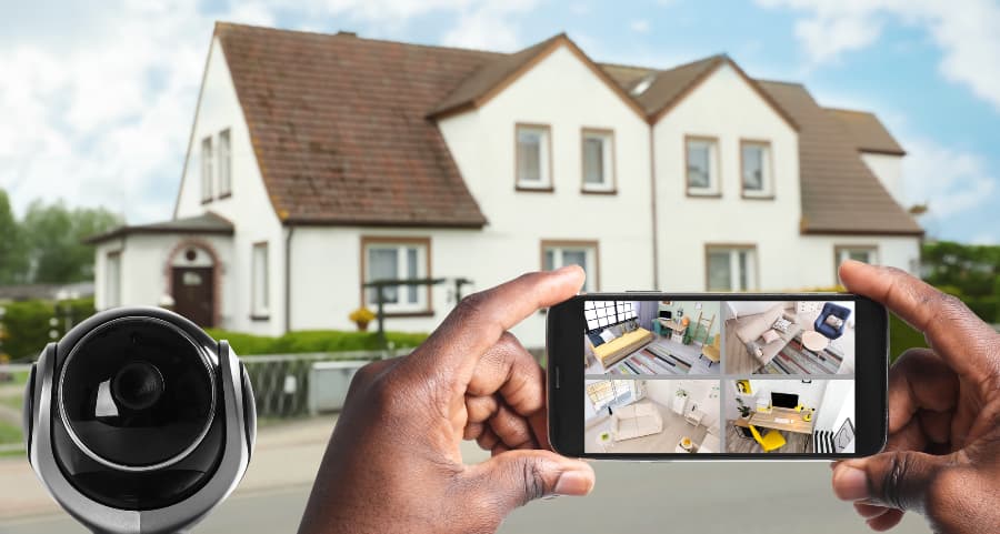 Man holding smartphone and viewing footage from video cameras